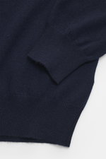 Nahaufnahme des navyfarbenen BRAUN Hamburg Cashmere Rundhalspullover Slim Fit mit feinem Strickbild, Rundhalsausschnitt und flexiblen Rippbündchen aus weichem, reinem Cashmere, fotografiert von oben.