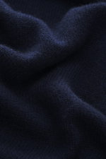 Nahaufnahme des weichen, mittelfeinen Strickbilds vom 04651/ A trip in a bag Cashmere Rollkragenpullover navy aus reinem Cashmere, fotografiert aus der Detail-Perspektive.