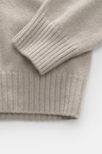 Nahaufnahme des 04651/ A trip in a bag Cashmere Rollkragenpullovers sand, Detail von Rippbündchen und mittelfeinem Strickbild in Slim Fit aus weichem, reinem Cashmere.
