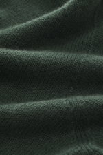 Nahaufnahme des grünen 04651/ A trip in a bag Cashmere Rollkragenpullovers, mittelfeines Strickbild, weicher Griff, reine Cashmere-Faser.