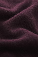 Nahaufnahme des dunkelvioletten 04651/ A trip in a bag Cashmere Rollkragenpullovers, weiches Cashmere, mittelfeines Strickbild, Rippbündchen sichtbar.