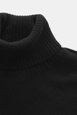 Nahaufnahme des schwarzen 04651/ A trip in a bag Cashmere Rollkragenpullovers von oben, mittelfeines Strickbild, weicher Griff, Slim Fit, anliegender Rollkragen, Rippbündchen.