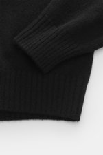 Schwarzer 04651/ A trip in a bag Cashmere Rollkragenpullover in Nahaufnahme, Fokus auf weichen, mittelfeinen Strick und Rippbündchen.