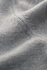 Nahaufnahme des von Braun Merino Rollkragenpullovers hellgrau aus reiner Merinowolle, mittelfeines Strickbild, Rollkragen und flexible Rippbündchen.