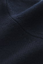 Nahaufnahme des von Braun Merino Rollkragenpullovers navy aus reiner Merinowolle mit mittelfeinem Strickbild, Oversized Fit, Rollkragen und flexiblen Rippbündchen.
