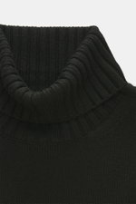 Nahaufnahme des von Braun Merino Rollkragenpullover schwarz, mittelfeines Strickbild, Oversized Fit, Rollkragen und flexible Rippbündchen aus reiner Merinowolle.