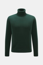 Frontale Nahaufnahme des dunkelgrünen von Braun Merino Rollkragenpullovers mit mittelfeinem Strickbild, Oversized Fit und Rippstrick-Kragen.