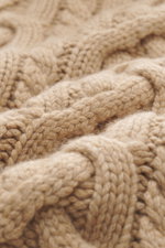 Nahaufnahme des groben Strickbilds mit Zopfstrickmuster eines hellbraunen Brunello Cucinelli Cashmere Rollkragenpullovers aus reiner Cashmere mit weichem Griff, anliegendem Rollkragen, Regular Fit und flexiblen Rippbündchen.