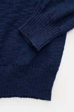 Close-up top-down view of the cuff and hem of the 04651/ A trip in a bag Crew neck jumper navy, made from pure cotton with a soft feel, fine knit, flammé effect, regular fit, crew neck, and stretchy knit bands, ideal for warmer days in spring.