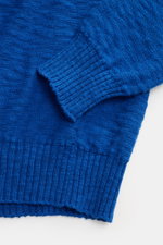 Close-up top-down view of the sleeve and hem of the 04651/ A trip in a bag Crew neck jumper blue, showing fine cotton knit with flammé effect and stretchy ribbed cuffs.

Description: <p>Ideal for warmer days: This crew neck jumper, made from pure cotton b