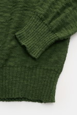 Close-up top view of 04651/ A trip in a bag Crew neck jumper dark green showing finely knit pure cotton fabric, stretchy knit bands on cuff and hem.

<p>Ideal for warmer days: This crew neck jumper, made from pure cotton by 04651/ A TRIP IN A BAG, is the 
