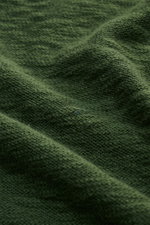 Close-up view of the dark green fabric texture of the 04651/ A trip in a bag Crew neck jumper showing fine knit and flammé effect.

<p>Ideal for warmer days: This crew neck jumper, made from pure cotton by 04651/ A TRIP IN A BAG, is the perfect staple for