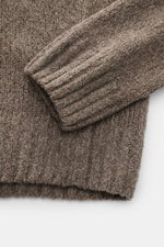 Nahaufnahme des taupefarbenen 04651/ A trip in a bag Rundhalspullovers 'Grainy Crew' mit weicher Bouclé-Struktur, Slim Fit und Rippbündchen.