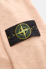 Nahaufnahme des Stone Island Rundhalspullover apricot mit feinem Strickbild, rolliertem Saum und Kompass-Badge seitlich am Ärmel.