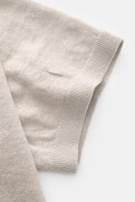 Nahaufnahme des Ärmels vom C.P. Company Kurzarmpullover grau aus feinem, weichem Leinenstrick mit elastischem Rippbündchen, seitliche Perspektive.
