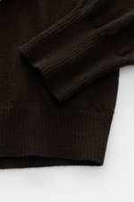 Nahaufnahme des dunkelbraunen B.F. Knitwear Cashmere Rundhalspullovers von oben, feines, luftiges Strickbild, elastische Rippbündchen, Slim Fit, reiner Cashmere.