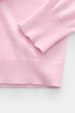 Nahaufnahme des B.F. Knitwear Cashmere Rundhalspullover rosé von unten schräg, zeigt feines, luftiges Strickbild, Slim Fit, Rundhals und elastische Rippstrick-Bündchen aus weichem, reinem Cashmere.
