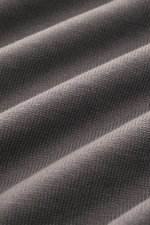 Close-up front view of Gran Sasso Kurzarmpullover graubraun fabric showing fine knit texture, pure cotton, soft touch, slim fit, round neckline, and comfortable ribbed cuffs. Frühlingshafte Leichtigkeit: Gefertigt aus reiner Baumwolle überzeugt der Kurzar