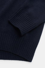 Close-up top-down view of the sleeve and lower ribbed hem of the von Braun Cashmere crew neck jumper navy, showcasing medium-fine knit pure Mongolian cashmere fabric with a soft feel and elasticated ribbed bands, designed for a slim fit.

<p>A smooth basi
