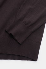 Nahaufnahme des dunkelbraunen von Braun Merino Rundhalspullovers aus feinem Merinowoll-Feinstrick, Slim Fit, Rundhalsausschnitt, elastische Rippbündchen.