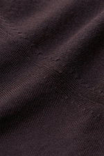 Nahaufnahme aus schräger Perspektive des von Braun Merino Rundhalspullover dunkelbraun mit feinem Strickbild, weichem Griff, Slim Fit, Rundhalsausschnitt und elastischen Rippbündchen aus reiner Merinowolle.
