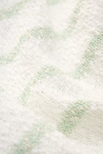Nahaufnahme des 04651/ A trip in a bag Rundhalspullover 'Mouline Striped' offwhite/salbei gestreift mit grobem Strickbild und klassischem Streifenmuster aus leichter Baumwolle.