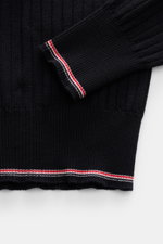 Nahaufnahme des navy Thom Browne Rundhalspullover aus elastischer, weicher Wolle mit feinem Rippstrick, Slim Fit, Rundhalsausschnitt und markentypischen Streifen am Bund, fotografiert von oben.