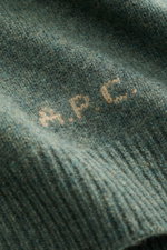 Nahaufnahme des A.P.C. Rundhalspullover 'Edmond' graugrün meliert aus reiner Wolle mit kontrastfarbenem Logo am Bund, Detailansicht.