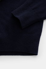 C.P. Company Rundhalspullover navy, Detailaufnahme Ärmel und Bund, mittelfeines Strickbild, weicher Griff, Raglanärmel mit Zipper-Tasche, Rippbündchen, Wolle-Microfaser-Mix.