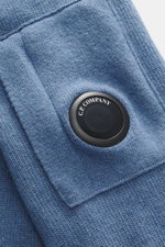 Close-up, angled view of the C.P. Company Crew neck sweater grey blue showing the iconic lens detail on the sleeve pocket. 

Description:  
<p>Timeless casual favorite: The knit sweater from C.P. COMPANY combines pleasant warmth with urban aesthetics and 