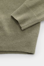 C.P. Company Rundhalspullover graugrün in Nahaufnahme von oben, mittelfeines Strickbild, weicher Griff, Raglanärmel mit Zipper-Tasche, flexible Rippbündchen.