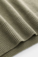 C.P. Company Rundhalspullover graugrün im Detail, nah fotografiert von oben, mittelfeines Strickbild, weicher Griff, Rippbündchen sichtbar.