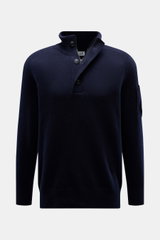 C.P. Company Troyer navy aus weicher Schurwolle, Regular Fit, mittelfeines Strickbild, Troyer-Kragen mit Knöpfen, Zipper-Tasche am Oberarm, frontal fotografiert.