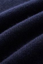 Nahaufnahme des weichen Strickstoffs in Dunkelblau, Detailbild des C.P. Company Troyer navy aus Schurwolle mit mittelfeinem Strickbild.
