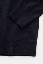 Nahaufnahme des linken Ärmels mit geripptem Bündchen und feinem Strickbild des navyfarbenen C.P. Company Rundhalspullover navy aus Woll-Mix, von oben fotografiert.