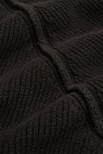 Nahaufnahme des feinen Strickbildes und weichen Griffs des schwarzen C.P. Company Rundhalspullover aus Baumwoll-Chenille.