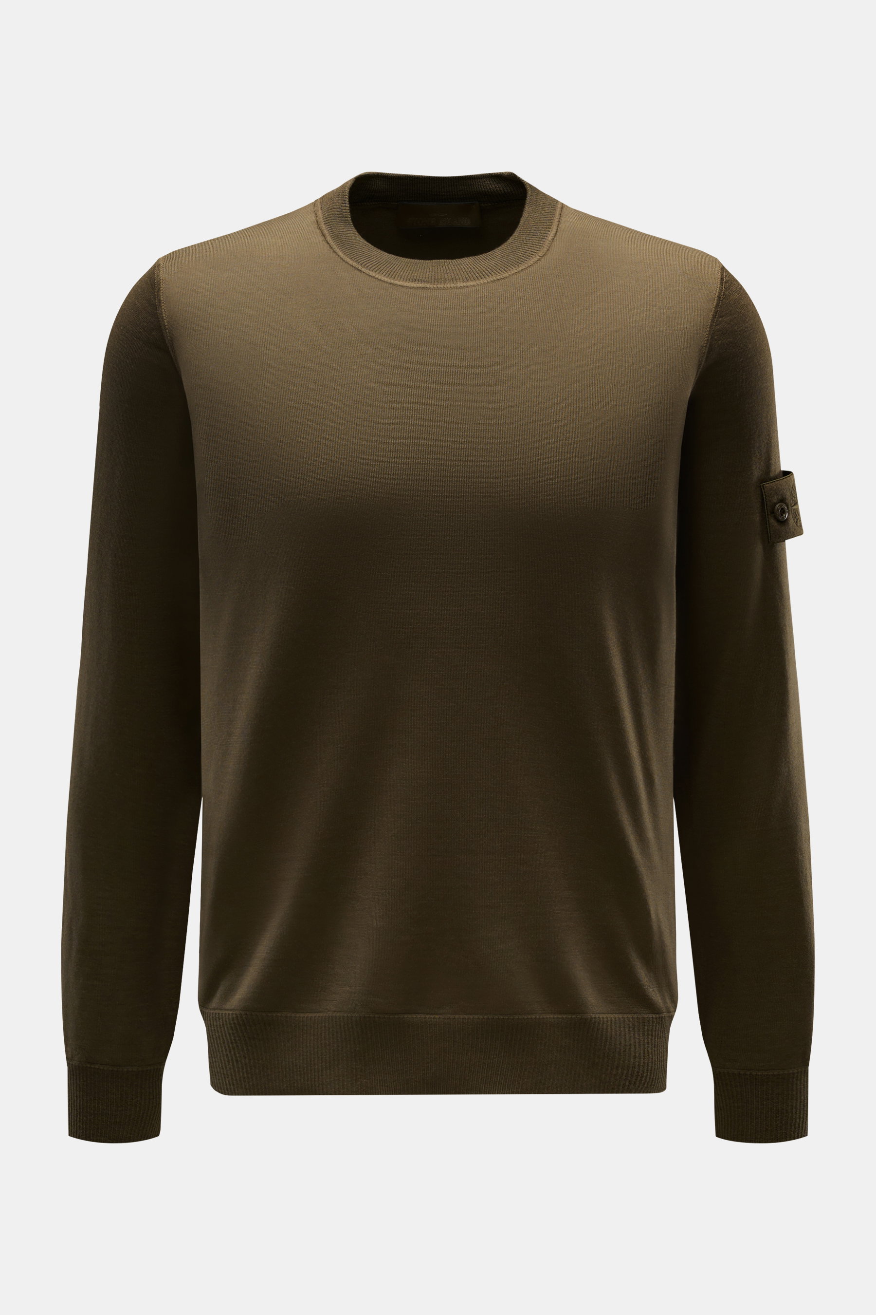 Stone Island Rundhalspullover 'Ghost Piece' dark olive, Slim Fit aus weicher Wolle, fein gestrickt, frontale Nahaufnahme mit Kompass-Badge am Oberarm.