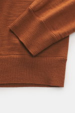 Stone Island Rundhalspullover 'Ghost Piece' rostbraun, Detailaufnahme Ärmel und Saum, reine Wolle, Slim Fit, tonales Kompass-Badge, elastische Rippbündchen.
