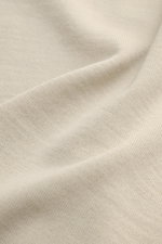 Stone Island Rundhalspullover 'Ghost Piece' beige aus feiner Wolle mit tonalem Kompass-Badge, weichem Griff und feinem Strickbild, Detailaufnahme Stoffstruktur.