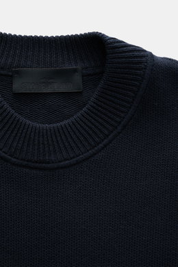 Nahaufnahme des Stone Island Rundhalspullover 'Ghost Piece' navy, Baumwoll-Cashmere-Mix, weicher Griff, Regular Fit, Rundhalsausschnitt, tonales Kompass-Badge, Rippbündchen, mittelfeines Strickbild, von oben fotografiert.