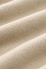Nahaufnahme des Stone Island Rundhalspullover 'Ghost Piece' sand aus Baumwoll-Cashmere-Mix, mittelfeines Strickbild, weicher Griff, Perspektive schräg von oben.