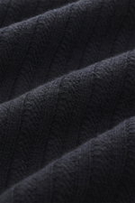 Nahaufnahme des Stone Island Rundhalspullover 'Ghost Piece' navy mit mittelfeinem Strickbild, weichem Griff, Mix aus Schurwolle und Cashmere, Slim Fit, Rundhalsausschnitt, tonalem Kompass-Badge am Oberarm und elastischen Rippbündchen, fotografiert aus sch
