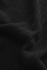 Nahaufnahme des Materials des Stone Island Rundhalspullover 'Ghost Piece' schwarz, mittelfeines Strickbild, Mix aus Schurwolle und Cashmere, weicher Griff, Slim Fit, Rundhalsausschnitt, tonales Kompass-Badge am Oberarm, elastische Rippbündchen, Stoffdetai