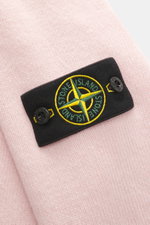 Close-up front view of Stone Island Crew Neck Sweater 'Lambswool' rose showing warm wool blend, soft touch, medium-fine knit, contrast stripes, slim fit, crew neckline, compass badge on upper arm, and ribbed cuffs. Stylish essential for the cold season: T