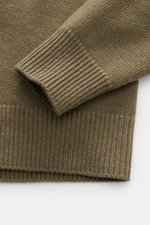 Stone Island Crew Neck Sweater 'Lambswool' grey green shown in close-up from above, highlighting ribbed cuffs and knit texture. Stylish essential for the cold season: This casual sweater by STONE ISLAND made of a warm wool blend impresses with distinctive