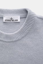 Stone Island Crew Neck Sweater 'Lambswool' smoky blue shown from above, featuring a ribbed crew neckline and knit texture. Stylish essential for the cold season: This casual sweater by STONE ISLAND made of a warm wool blend impresses with distinctive link