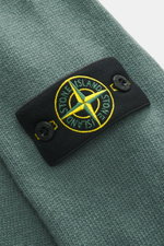 Stone Island Crew Neck Sweater 'Lambswool' grey green shown close-up from above, highlighting compass badge on sleeve. Stylish essential for the cold season: This casual sweater by STONE ISLAND made of a warm wool blend impresses with distinctive link-kni