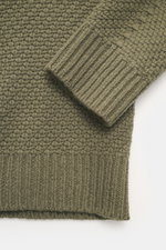 Nahaufnahme des Stone Island Rundhalspullover oliv von oben, Strick aus RWS-zertifizierter Schurwolle und Microfaser, leicht strukturierter Griff, voluminöses Strickbild, Regular Fit, Rundhalsausschnitt, Kompass-Badge am Oberarm, elastische Rippstrickbünd