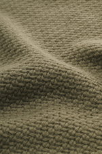 Nahaufnahme des Stone Island Rundhalspullover oliv, strick aus RWS-zertifizierter Schurwolle und Microfaser, voluminöses Strickbild, leichter Griff.