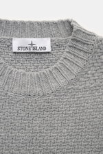 Nahaufnahme des Stone Island Rundhalspullover grau von oben, Strick aus RWS-zertifizierter Schurwolle und Microfaser, leicht strukturierter Griff, voluminöses Strickbild, Regular Fit, Rundhalsausschnitt, Kompass-Badge am Oberarm, elastische Rippstrickbünd